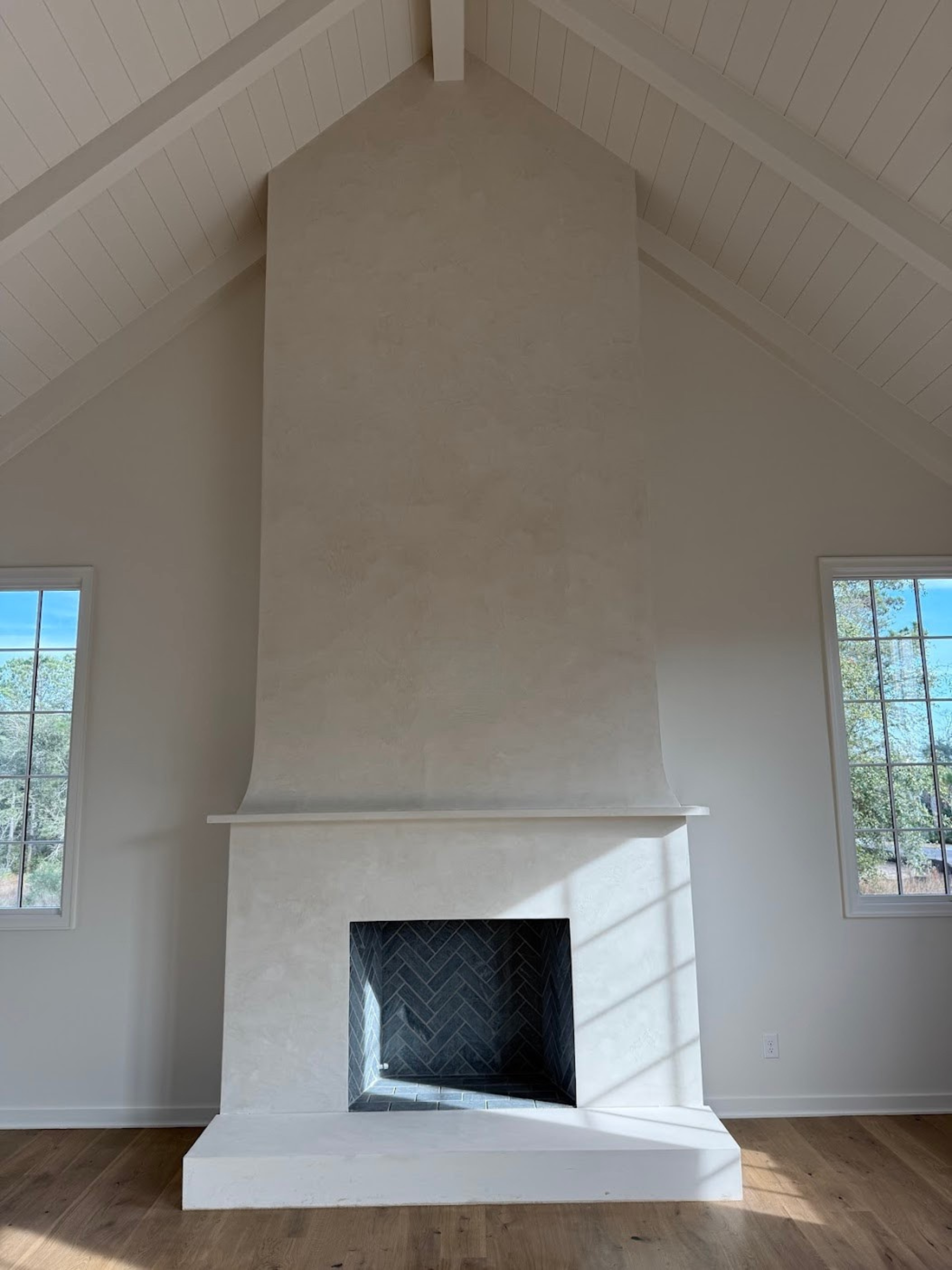 Two story Venetian Fireplace  in  Origami White to complement the surrounding elements and colors. The installation was out on Kiawah River and the builder was JacksonBuilt Custom homes. 