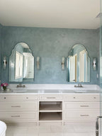 Light blue Venetian plaster wall in a Ravenel, SC master bathroom with burnish and polish finish, next to a custom vanity, created by Emily Pope Harris in collaboration with Jackson Built Custom Homes.