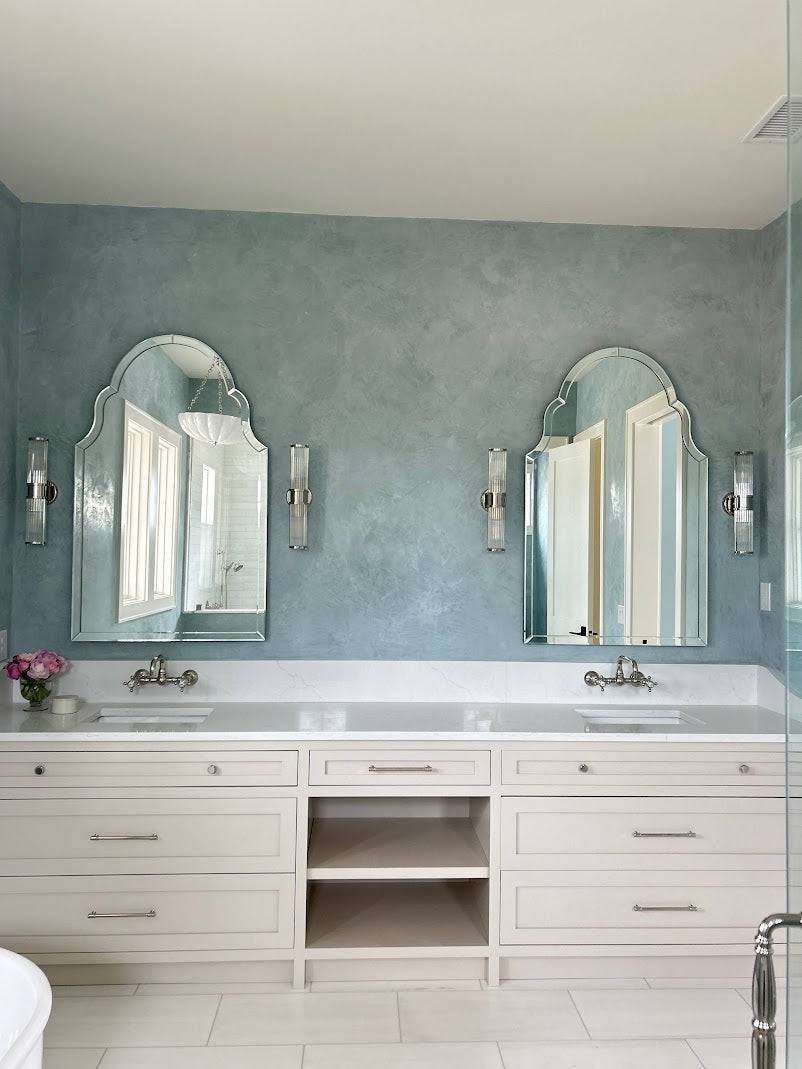 Light blue Venetian plaster wall in a Ravenel, SC master bathroom with burnish and polish finish, next to a custom vanity, created by Emily Pope Harris in collaboration with Jackson Built Custom Homes.
