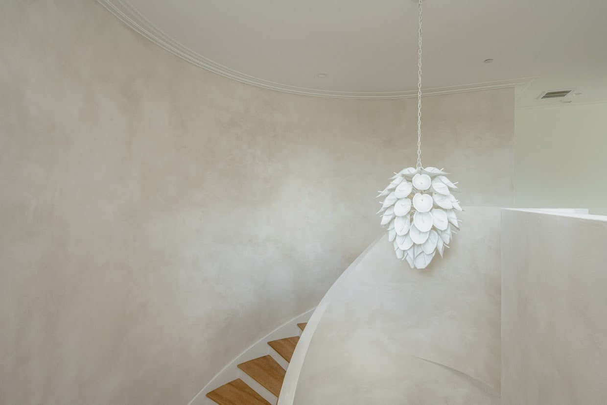 Image of a textured plaster installation on Daniel Island, SC in a two story staircase. The image is shot from the floor looking up to see the architectural detail and the movement of the plaster. 
