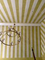 Custom installation done on a vaulted ceiling in a primary bedroom of venetian plaster stripes in Chartreuse and alabaster. 