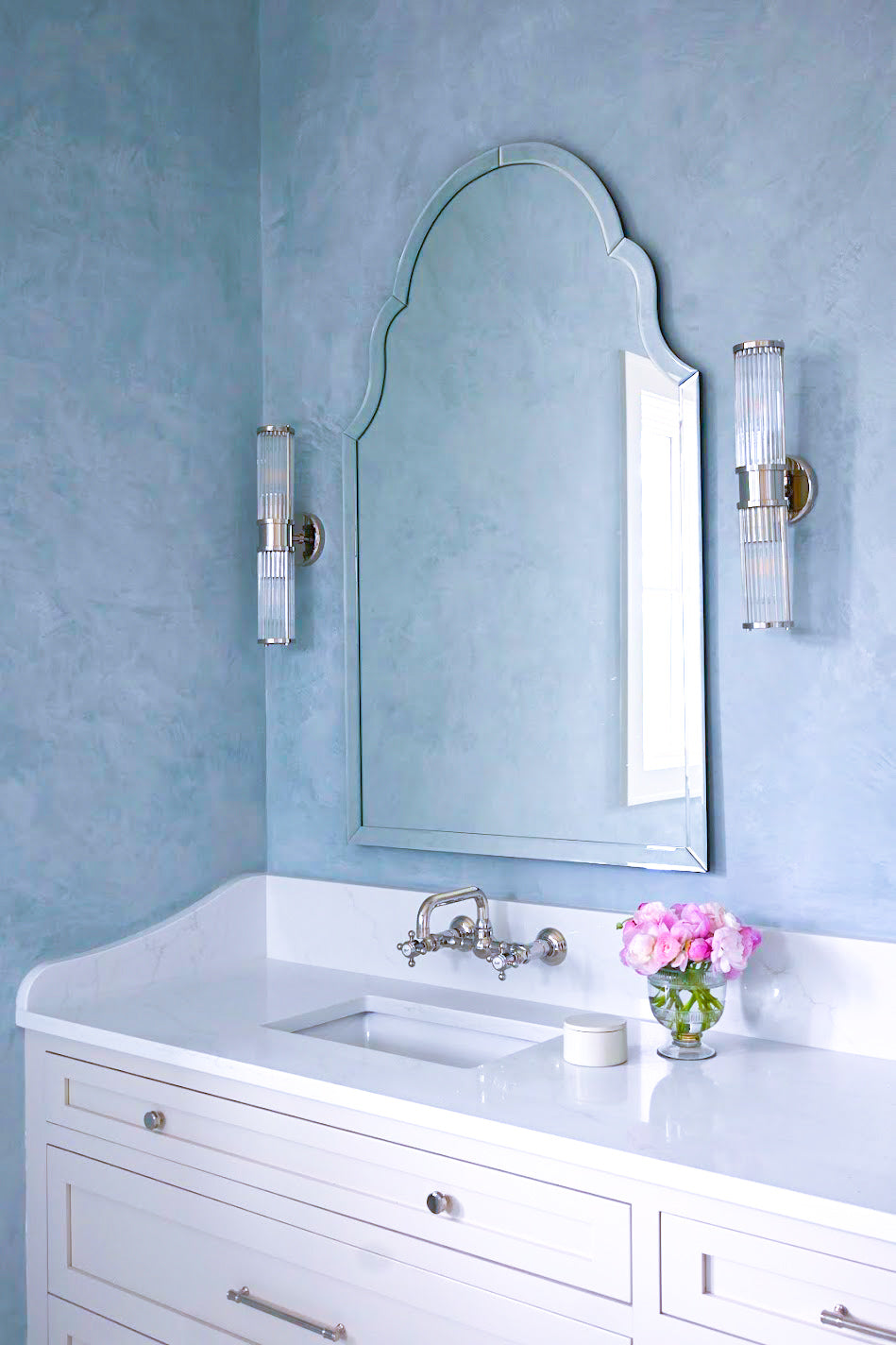 A light blue Venetian plaster installation done in Ravenel, SC in a primary bathroom. This corner shines and you can see all the movement, depth, texture and burnish which pulls the bathroom together. 