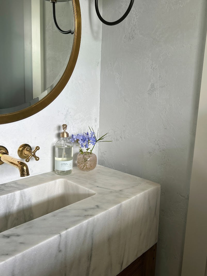 Close-up of heavily textured, matte dusty light blue Venetian plaster in a Daniel Island powder bathroom by Emily Pope Harris with Jackson Built Custom Homes.