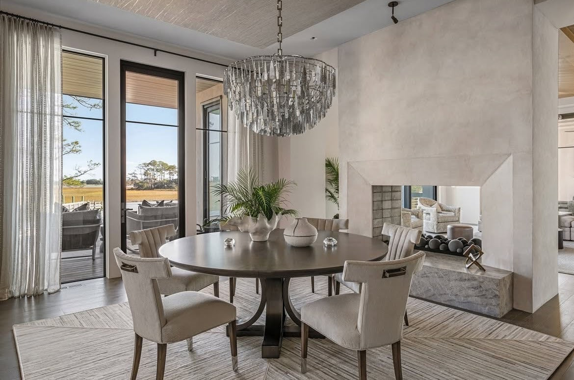 Double-sided fireplace on Kiawah Island with subtle textured plaster, showing gentle movement while allowing the marsh views to remain the focal point.