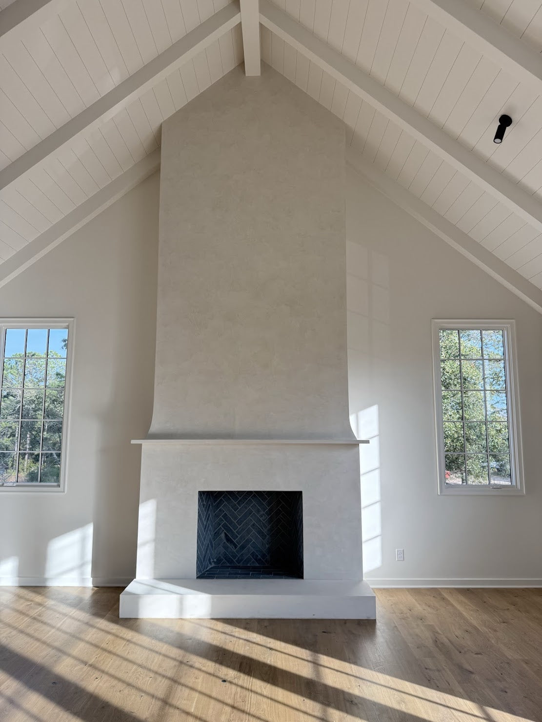 Full view of a two-story fireplace finished in custom cream Venetian plaster, hand-applied and burnished for a soft polished sheen at Kiawah River by Emily Pope Harris.