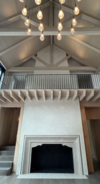 Tall two-story Venetian plaster fireplace in Egret White on Kiawah Island, showing subtle movement, variation, and burnish.