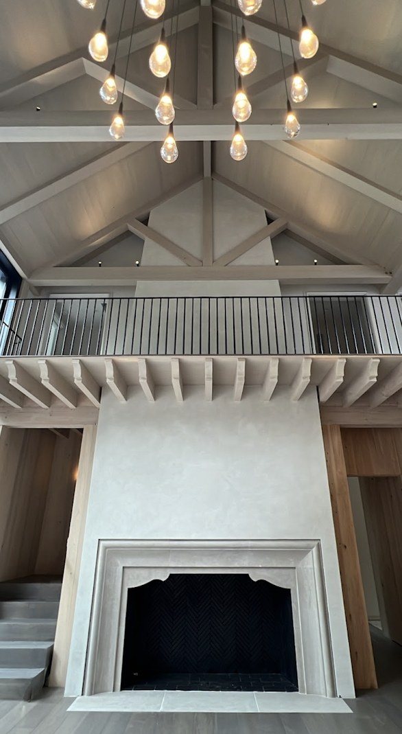 Tall two-story Venetian plaster fireplace in Egret White on Kiawah Island, showing subtle movement, variation, and burnish.