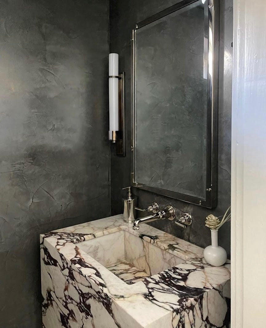 Black Venetian plaster in a powder bathroom with subtle burnish, showcasing texture and shine, by Emily Pope Harris in downtown Charleston.