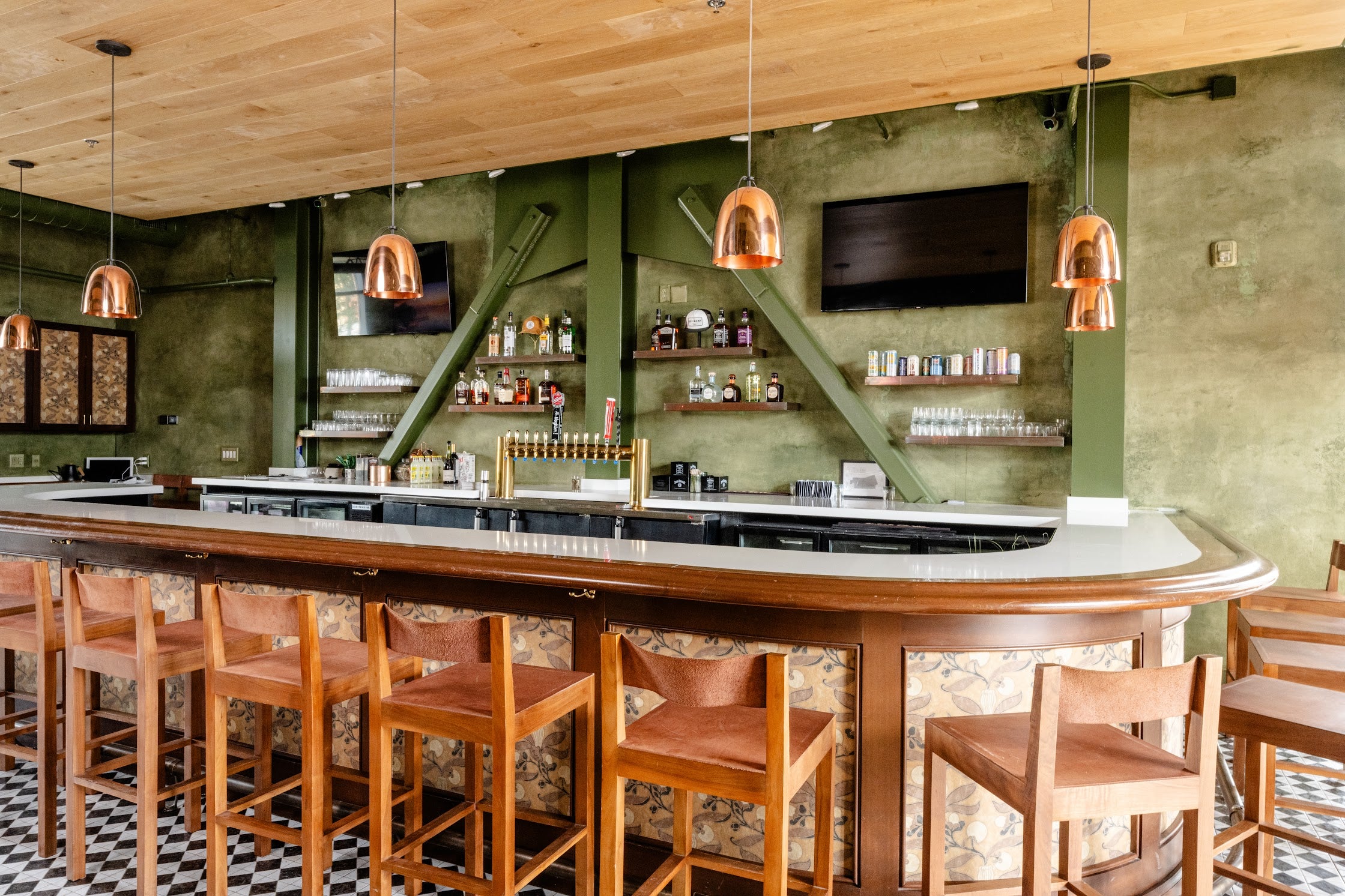 Full view of the bar at The Refinery featuring custom textured plaster walls with olive-green glazes and painted trim, creating a cohesive color-blocked commercial interior in Charleston, SC.